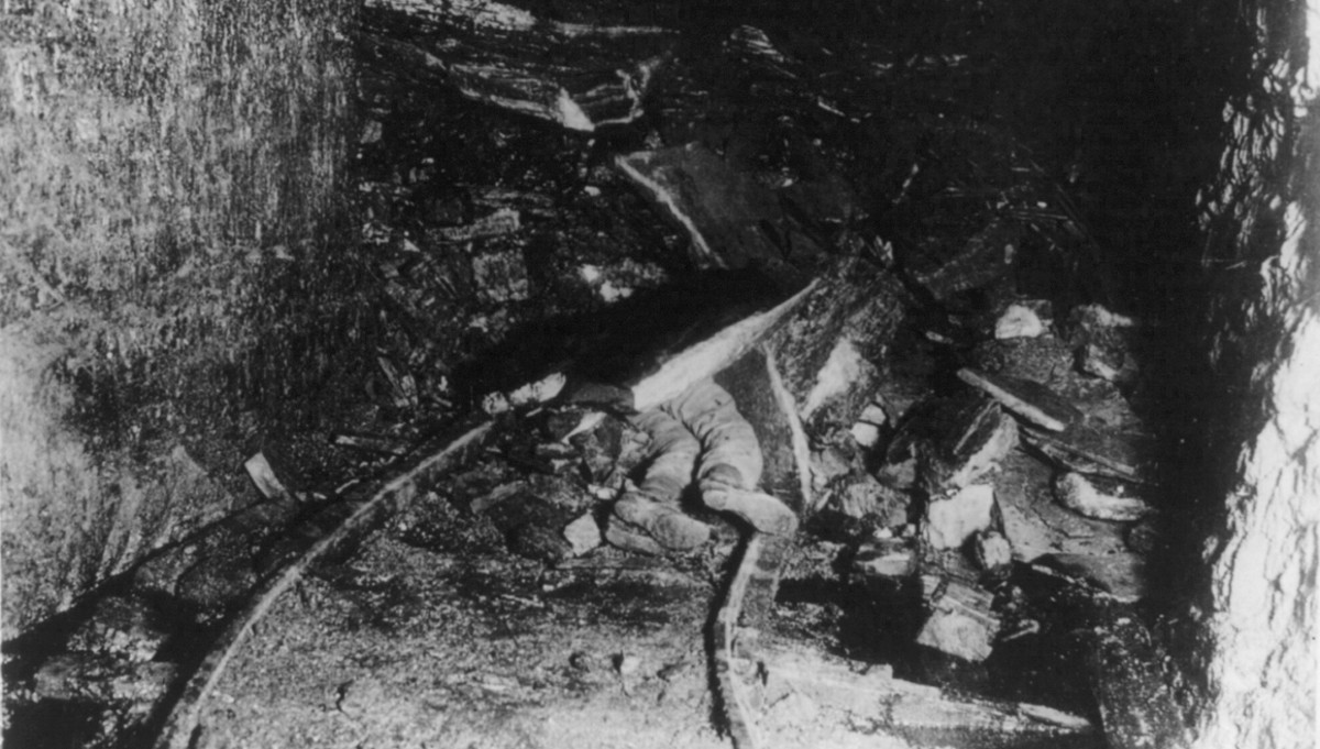 a black and white photograph of a coal miner buried by rocks and debris in a coal mine, c. 1909. (Source: loc.gov)
