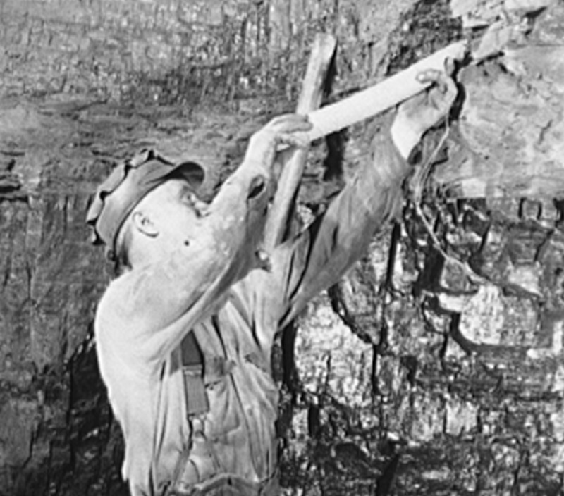 Coal miner "tamping" a charge after having already drilled the hole and set the explosive charge, c. 1930. (Source: loc.gov)