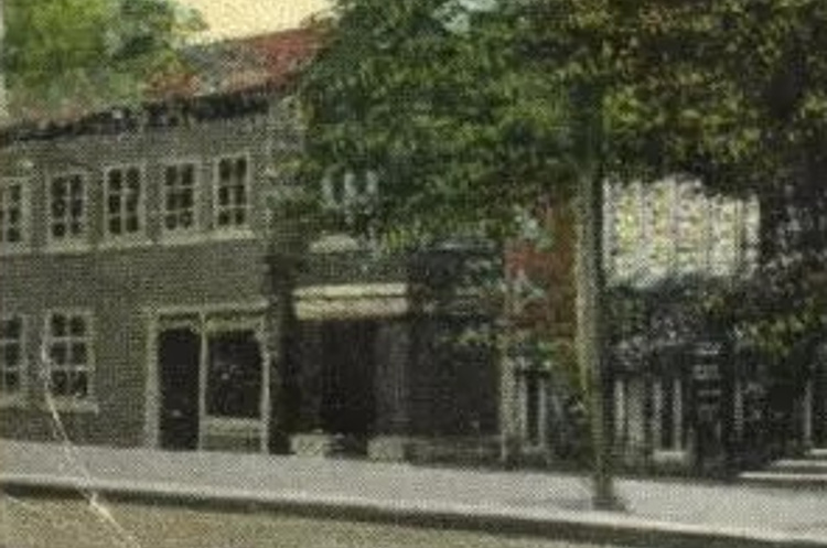 The Maurer tailor shop and residence (on left) depicted in an early 1920s postcard image. (Source: ebay.com)